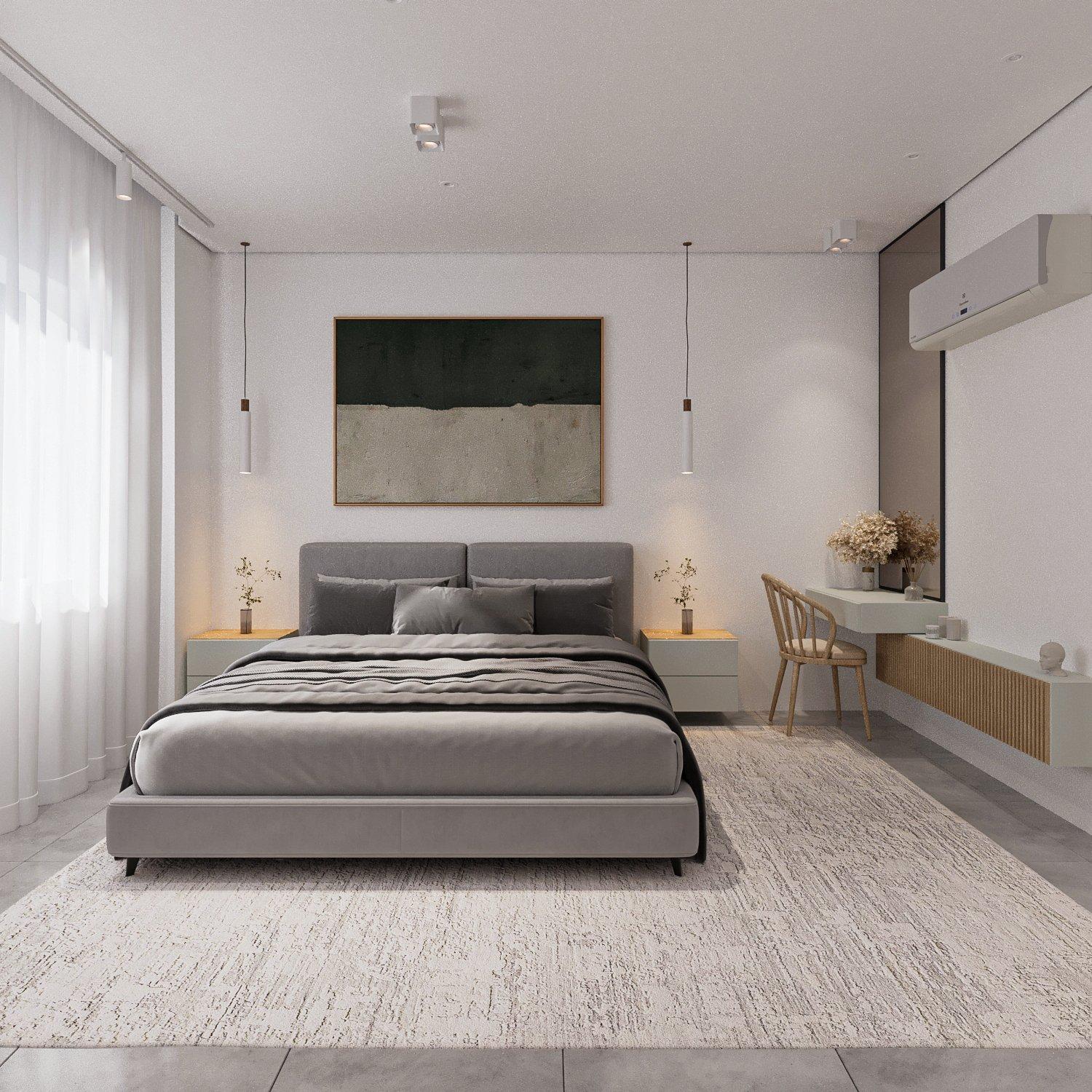 Bedroom with an upholstered grey bed, pendant lights, abstract painting and a small desk