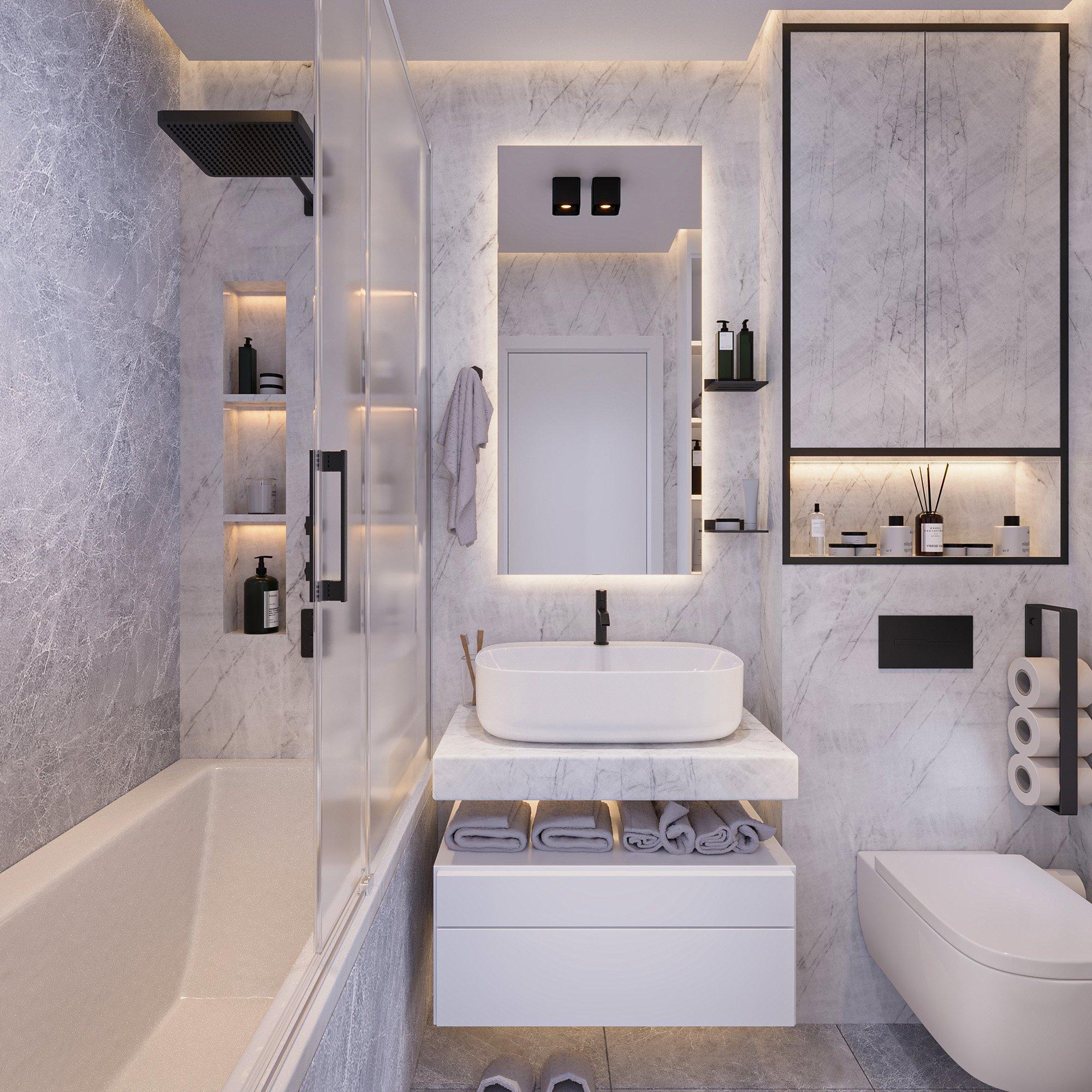 Bathroom vanity with backlit mirror, marble walls and a white bathtub